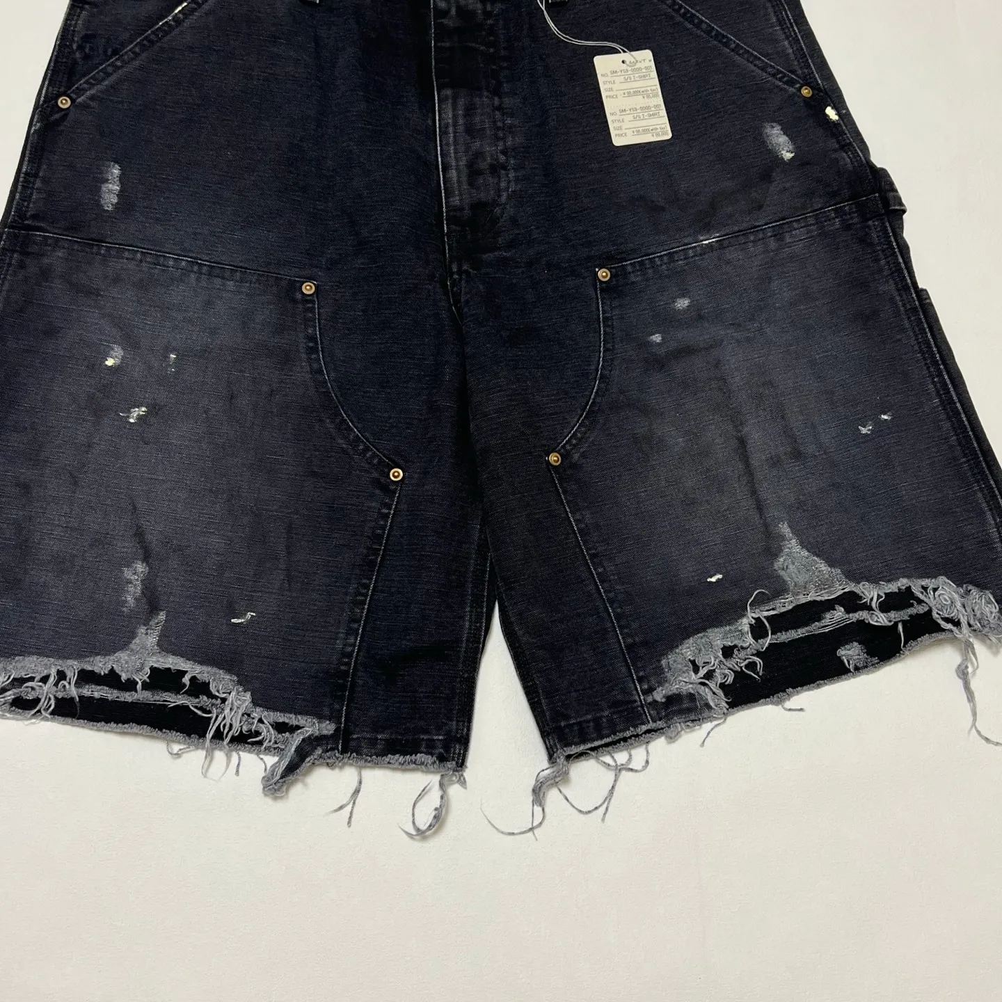 SAINT Mxxxxxx DOUBLE KNEE SHORTS/BLK Knee patches splashed with ink, washed and damaged denim shorts. Washed black S-XL. Custom woven and dyed denim denim with clear texture. Rewashed and faded to create local mottled fading/hole effects. Artificial distressing to simulate natural traces of wear. Original consistent damage treatment. Hand splashed ink and paint. Original consistent wash mark/pocket mark. Double knee patch. Rivet reinforcement. Improve functionality and enhance design.